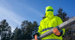 Worker in FrogWear HV GLO-P1 hi-vis winter parka and Bullhead Safety WL300-YG hi-vis thermal neck gaiter
